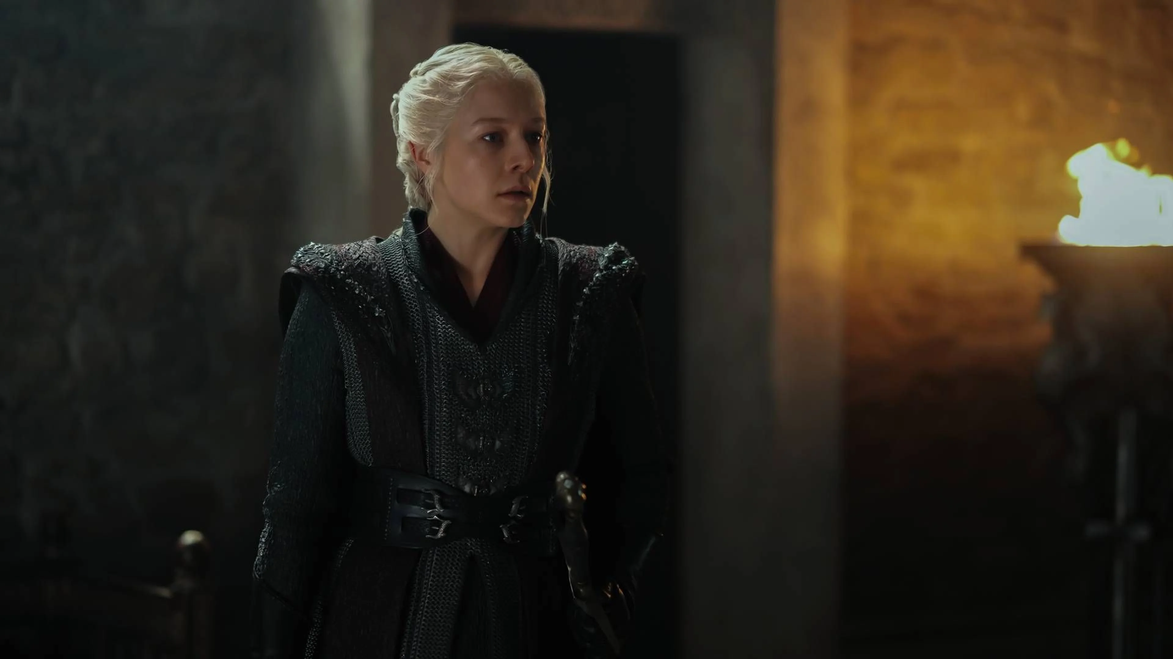 Emma D’Arcy as Rhaenyra Targaryen stands inside a torch-lit room in House of the Dragon Season 3.
