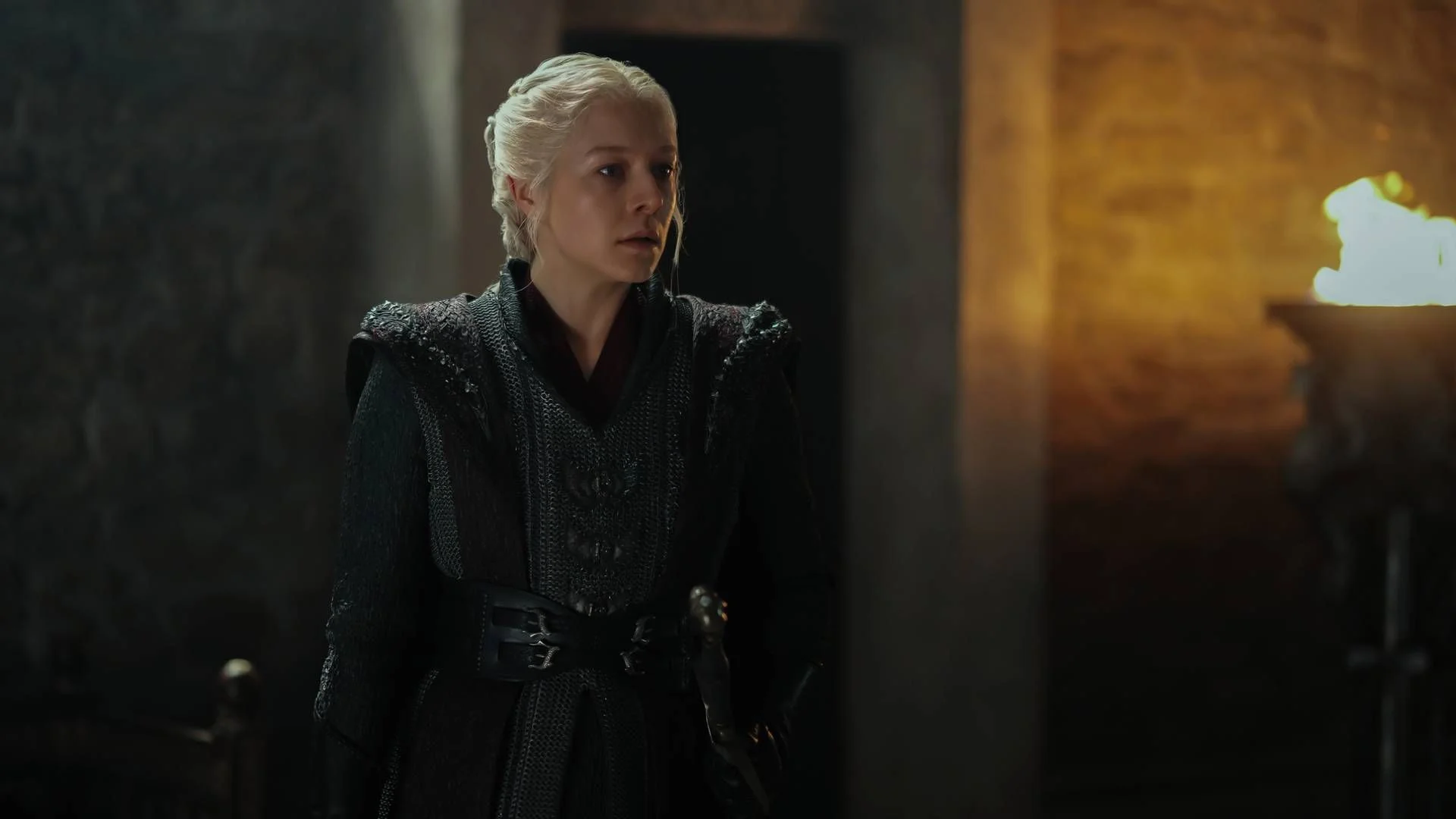 Emma D’Arcy as Rhaenyra Targaryen stands inside a torch-lit room in House of the Dragon Season 3.
