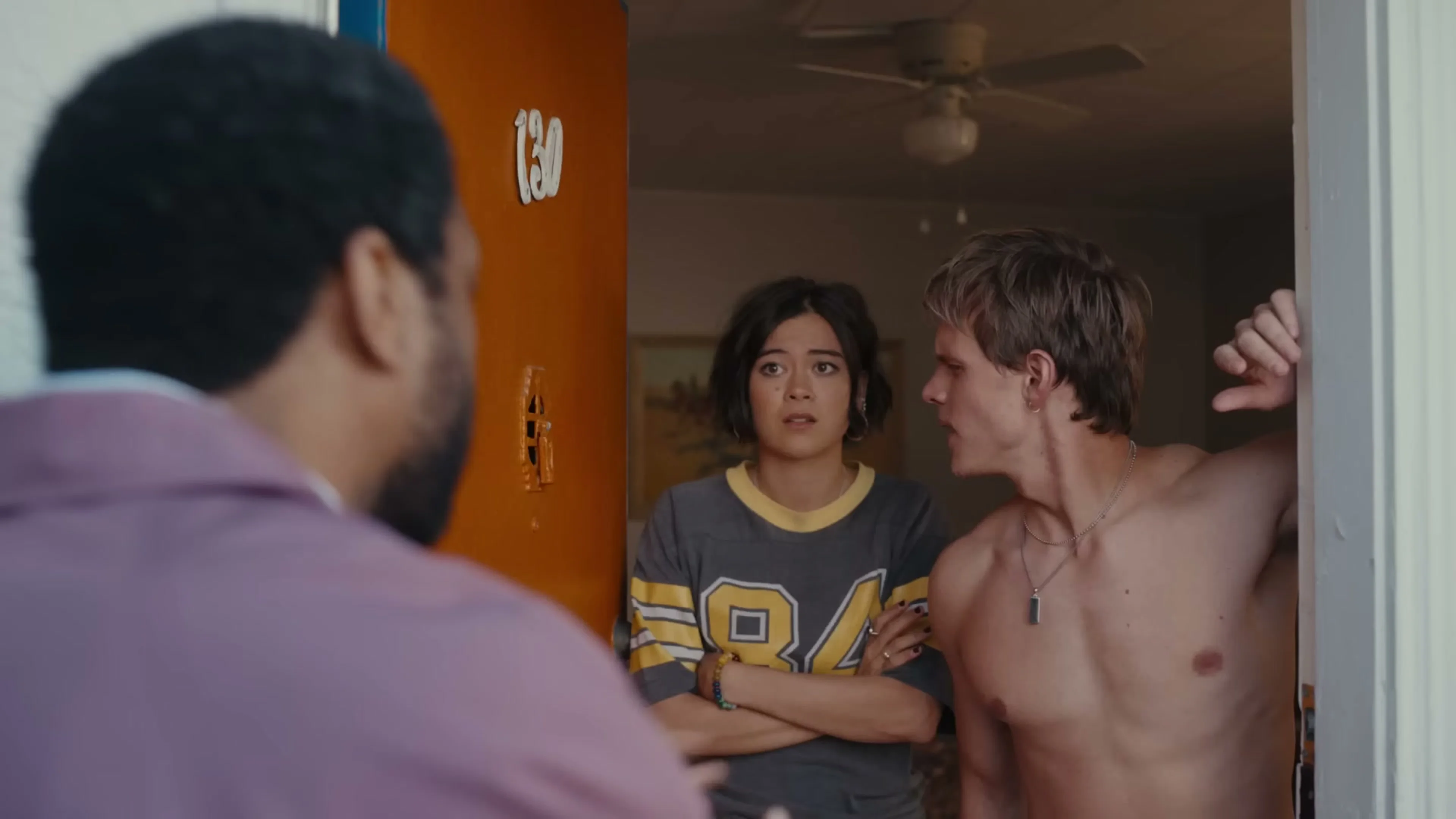 Kat and Bobby stand in an open doorway facing Clark.