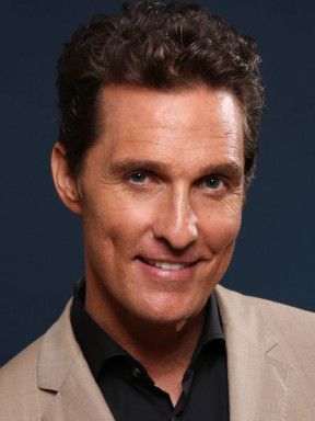 Portrait of Matthew McConaughey in a tan jacket and black shirt.