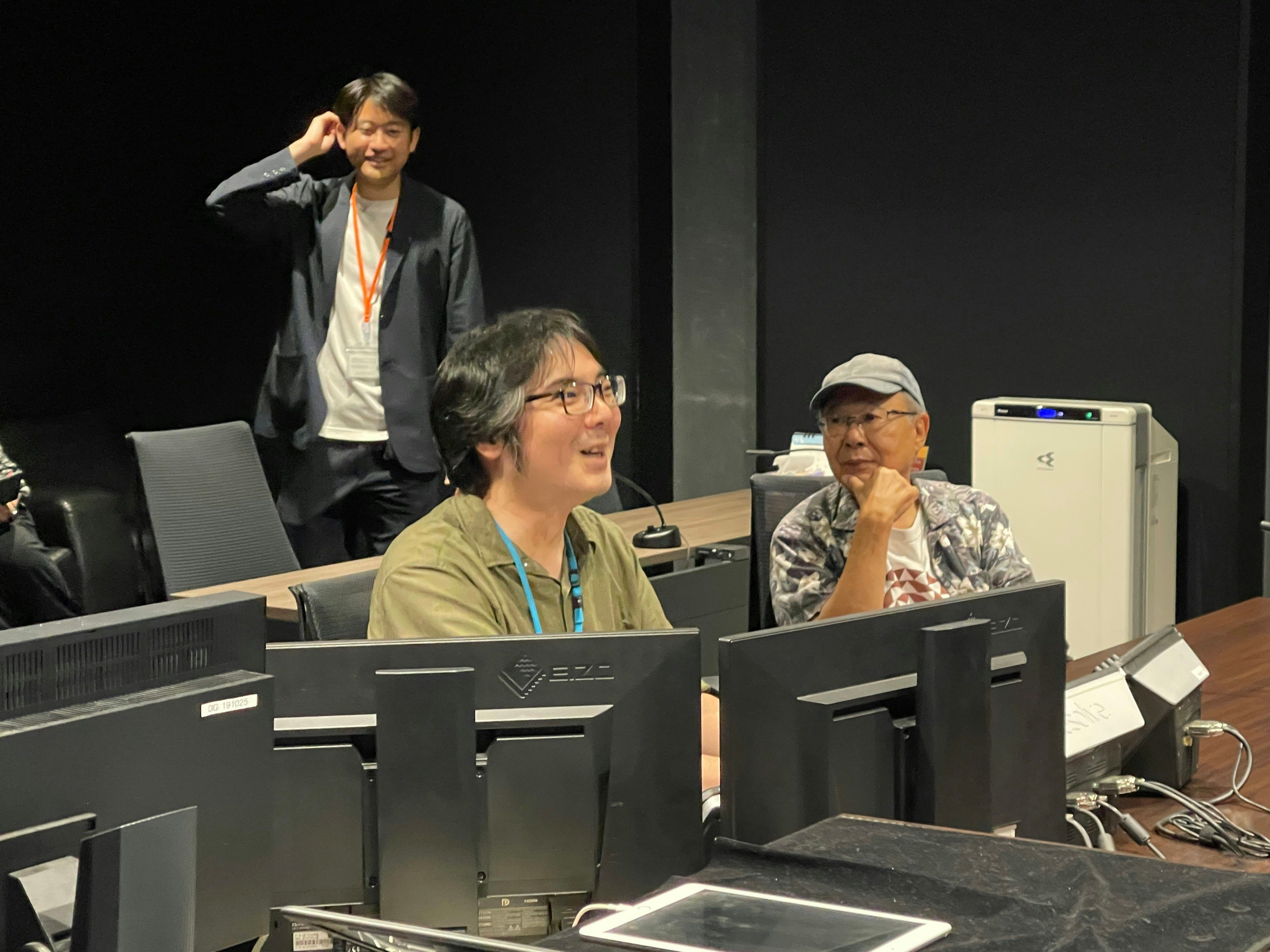 Three members of the Ninja Scroll restoration team review the image at a bank of monitors.