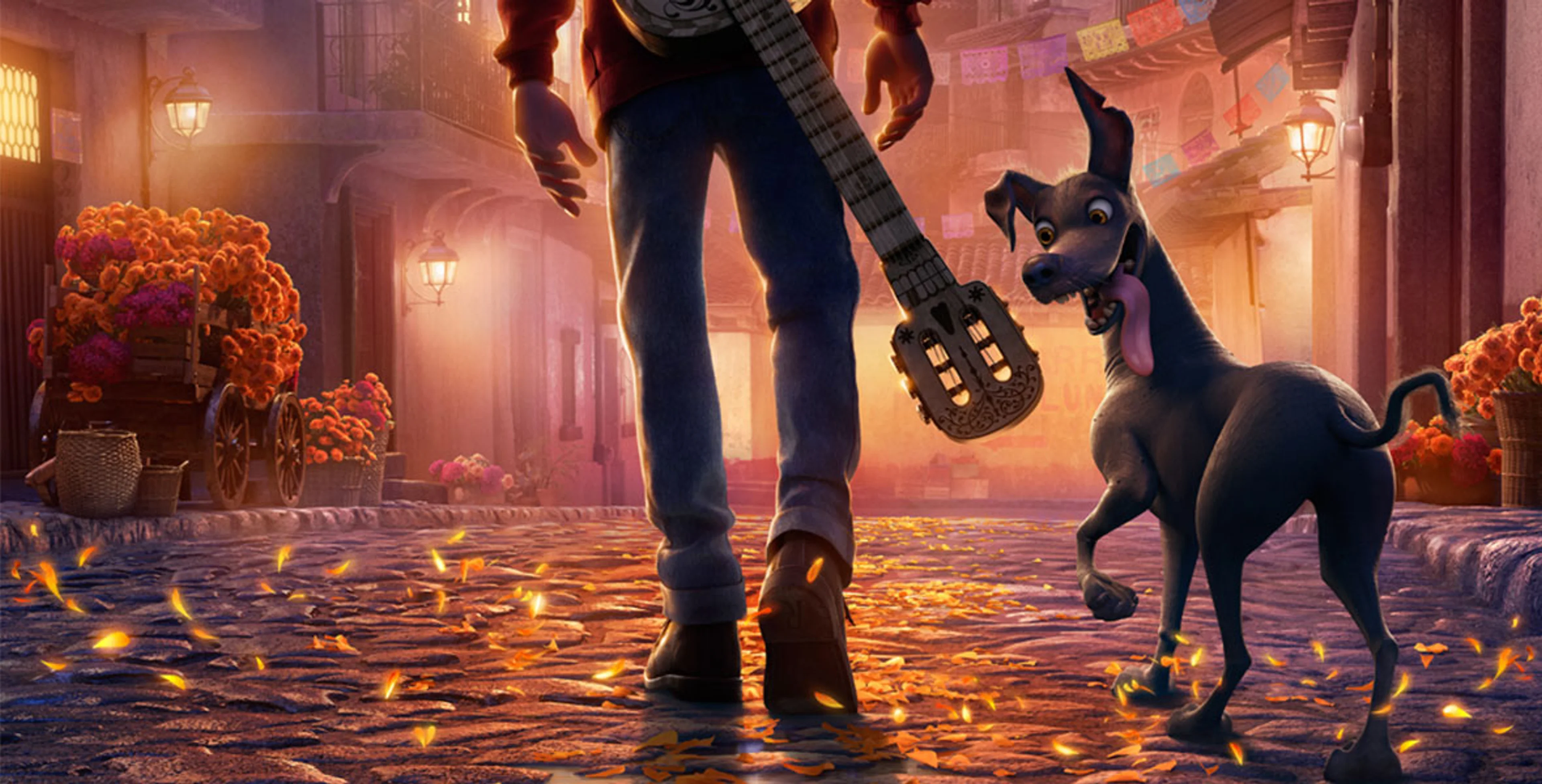 Miguel walks through a colorful street with Dante in an official Coco still.