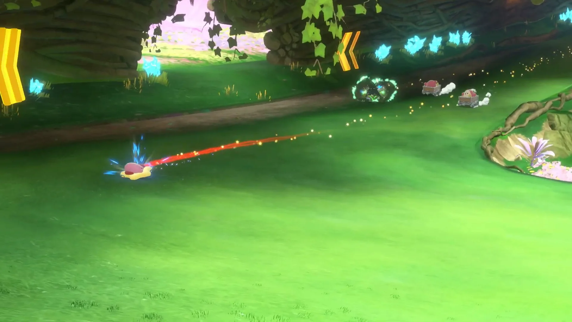 Official Nintendo UK Kirby Air Riders gameplay frame with Kirby on a Warp Star near yellow left-turn chevrons, blue charge sparks and other racers ahead.