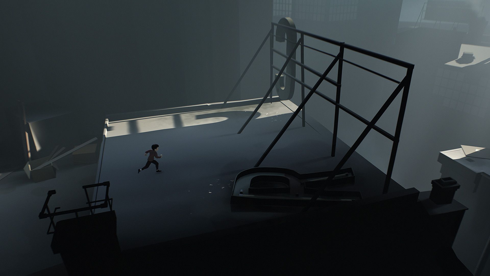 The boy runs beside a large tilted structure and metal stairs.