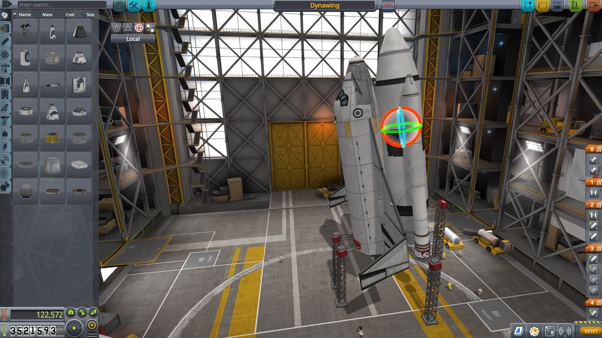 A tall rocket stands inside the Vehicle Assembly Building with a parts palette on the left and staging icons on the right.