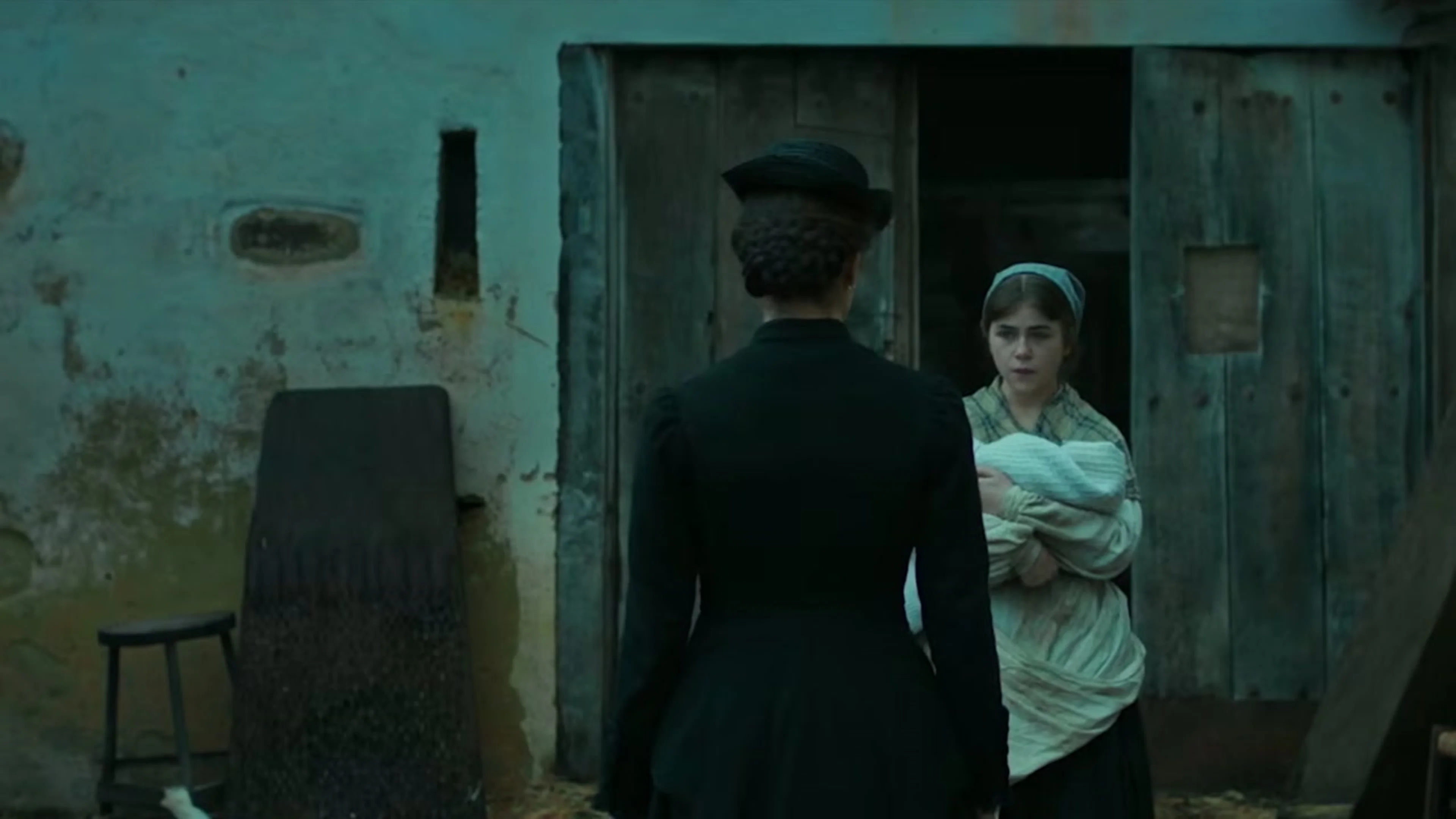 Ángela speaks with a woman outside a rural home in The Harvester.