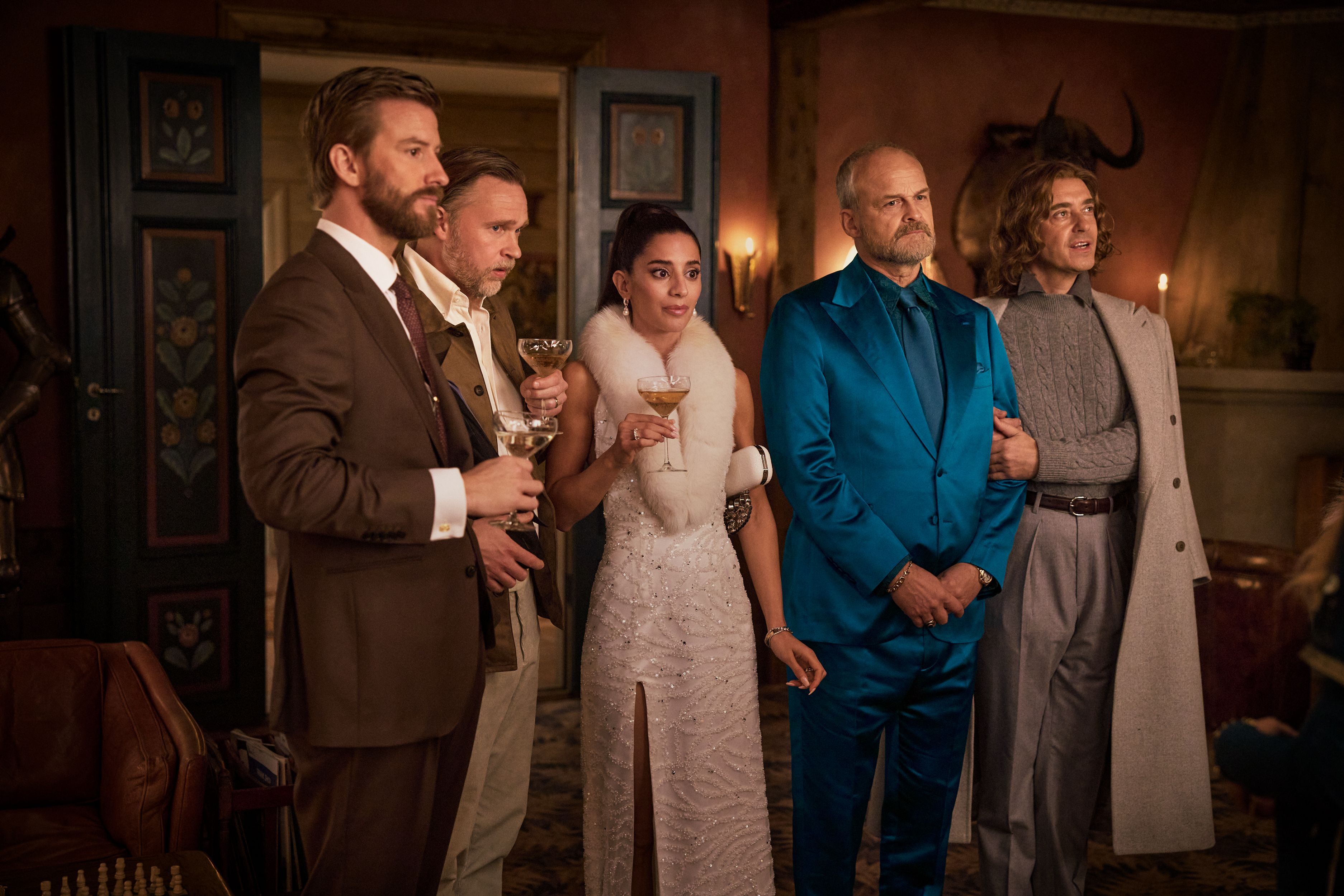 Guests stand together inside the farmhouse during a scene from The Storm.