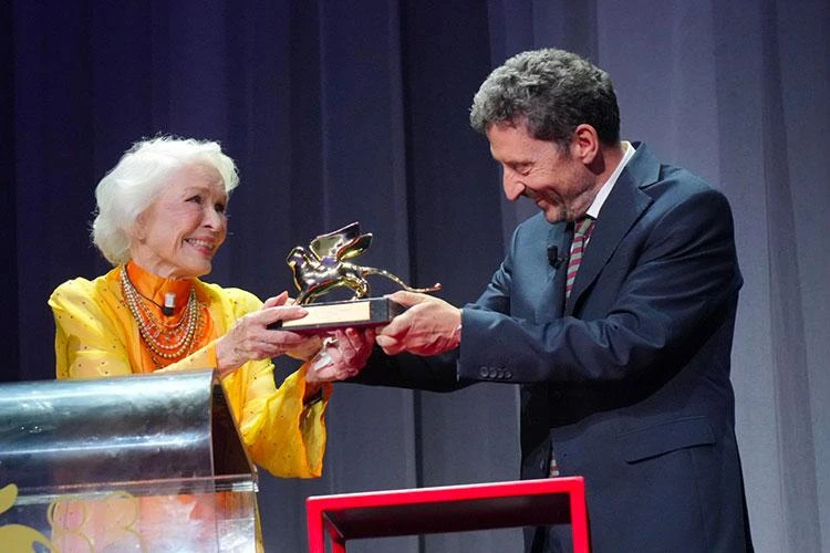 Ellen Burstyn, wearing yellow, receives the Golden Lion for Lifetime Achievement at the 2026 Venice Film Festival.