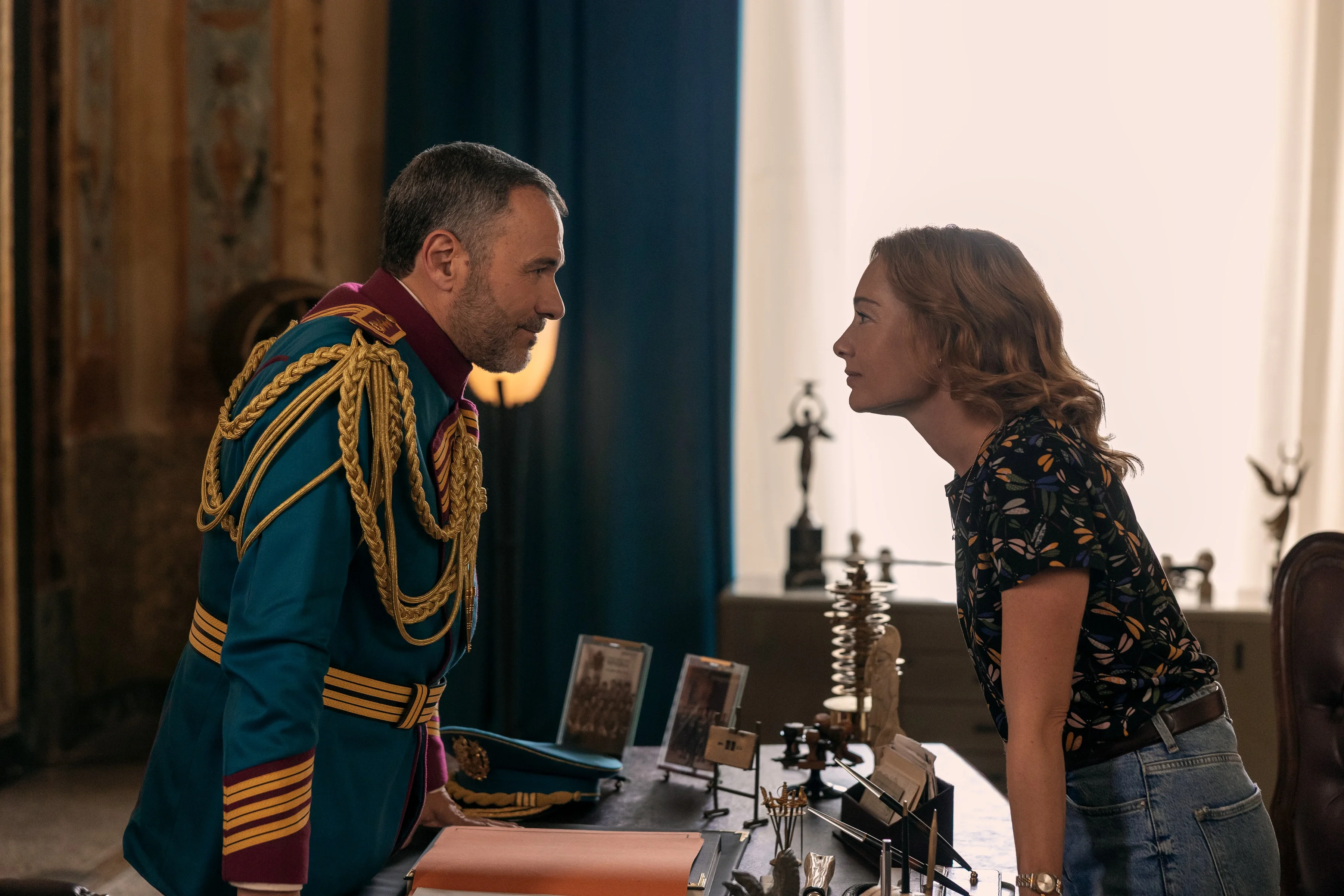 A uniformed officer speaks with a civilian woman in an official Minerva Academy still.