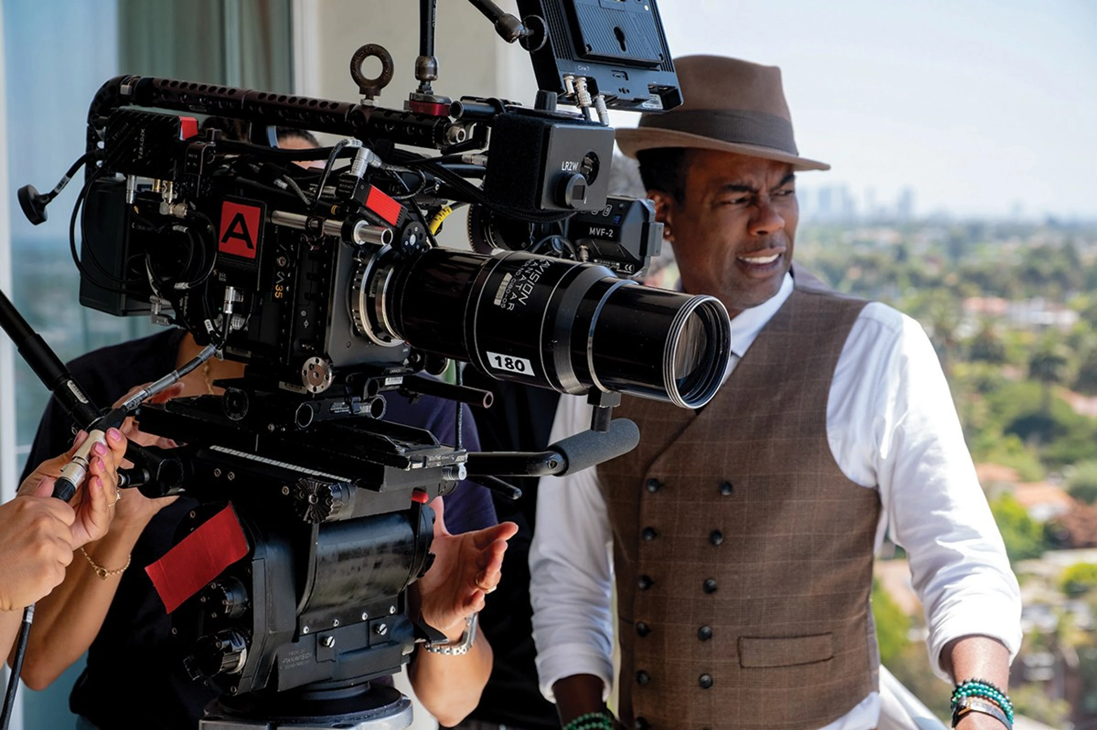 Chris Rock on location for Misty Green, standing behind the camera with crew nearby.