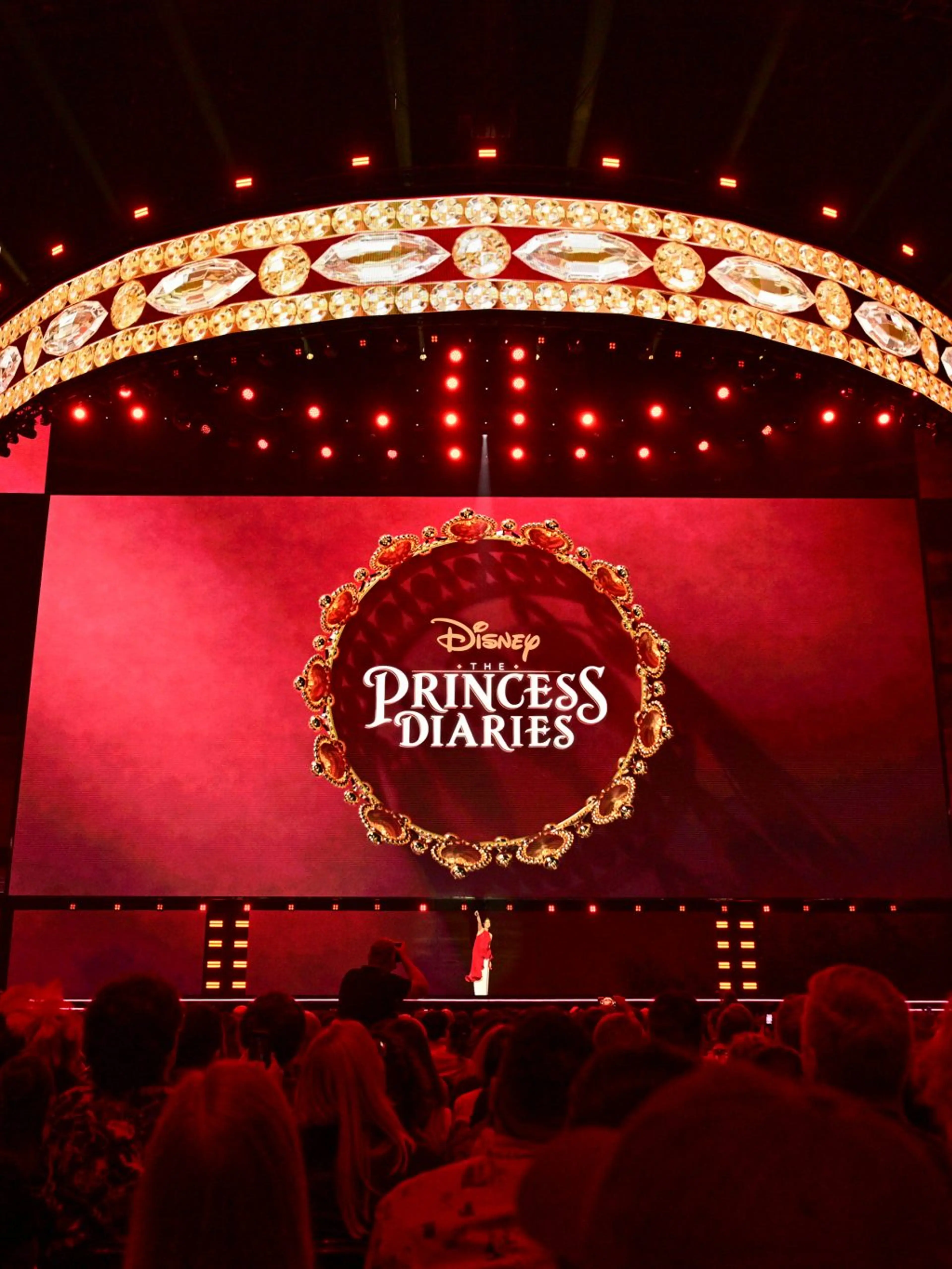 Anne Hathaway appears onstage at D23 2026 beneath The Princess Diaries logo.