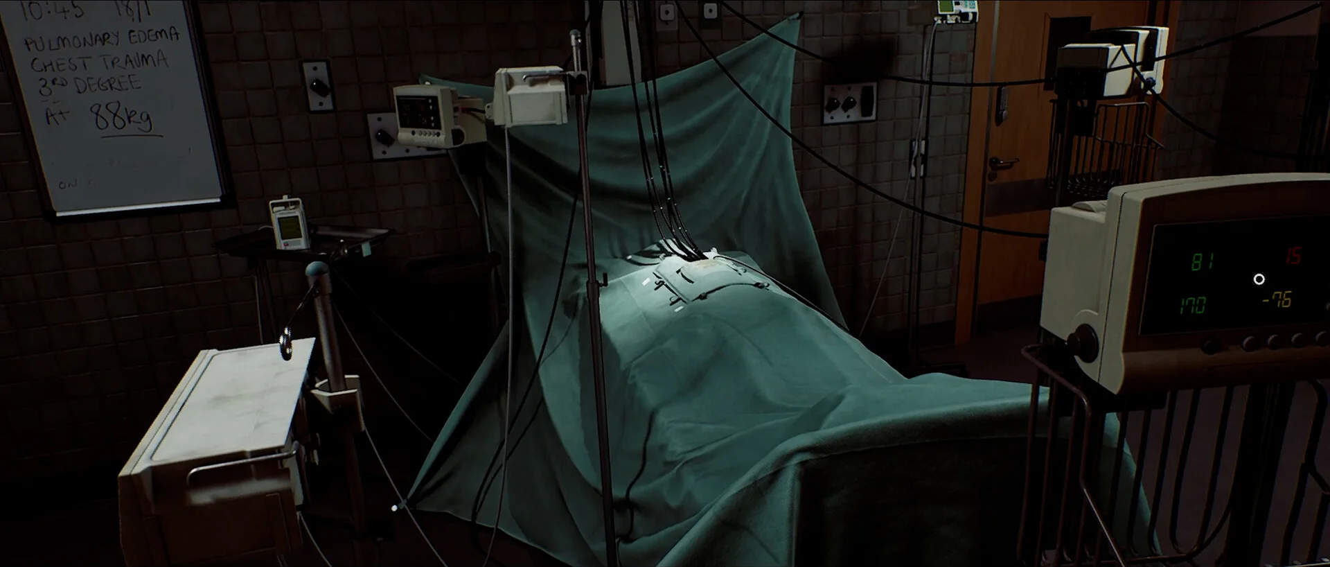 A clinical bed with a green covering sits beside wires and medical monitoring equipment.