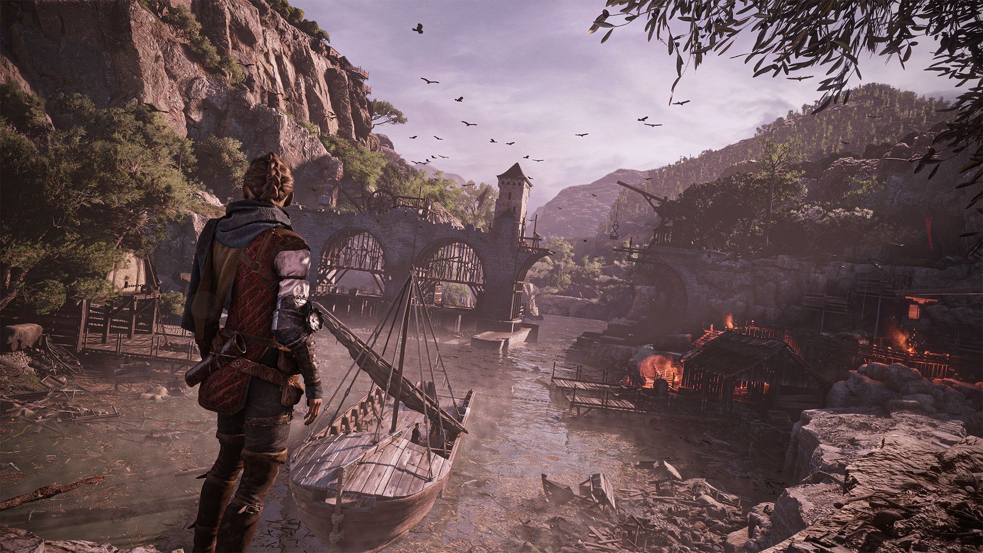Amicia overlooks damaged docks and a settlement beside a river.