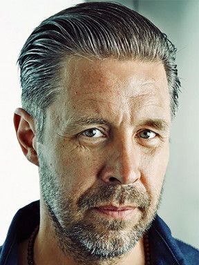Portrait of Paddy Considine with slicked-back hair and a short beard.