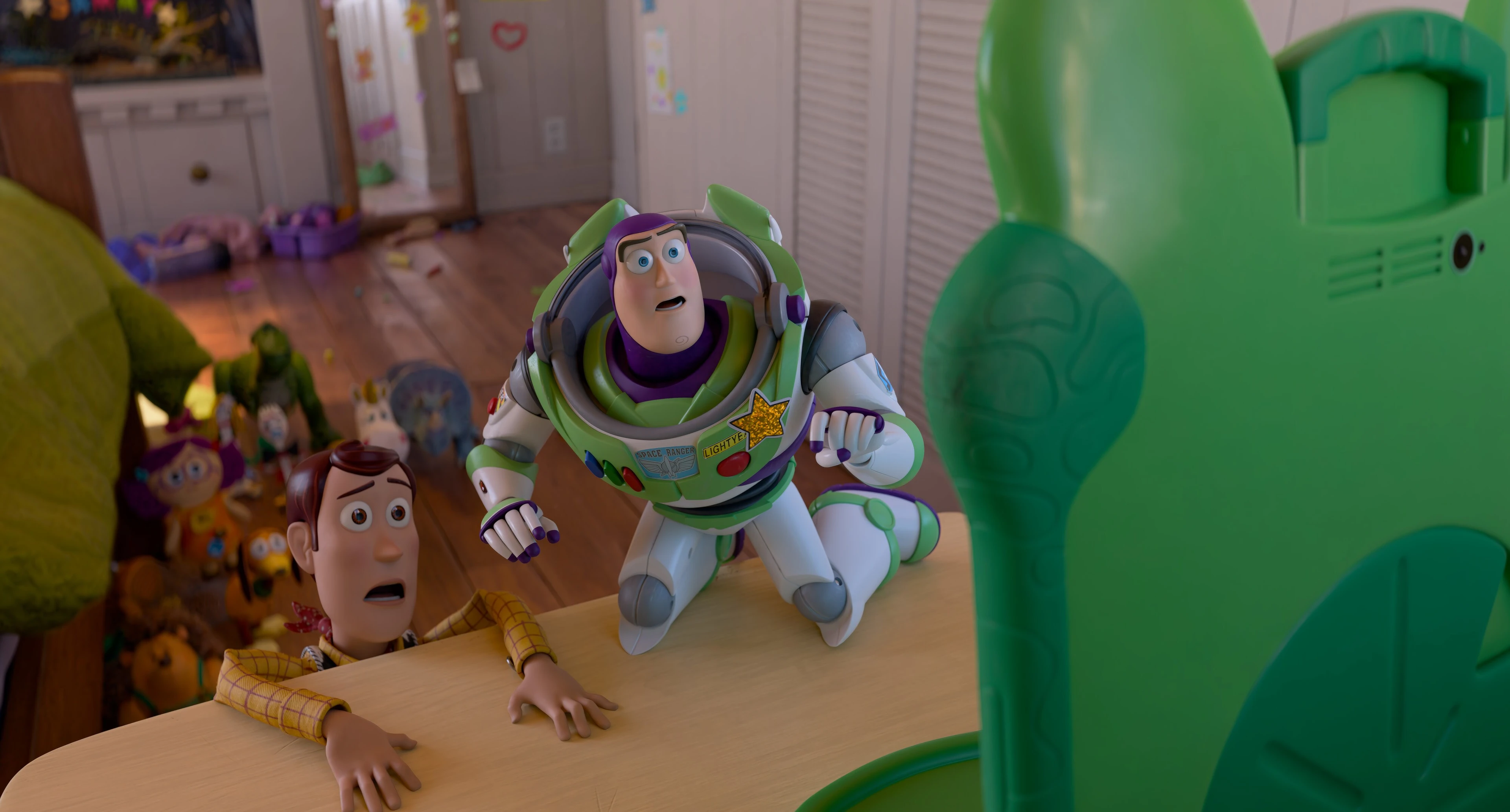 Buzz Lightyear and Woody react to Lilypad, a green tablet, in Bonnie’s room in Toy Story 5.